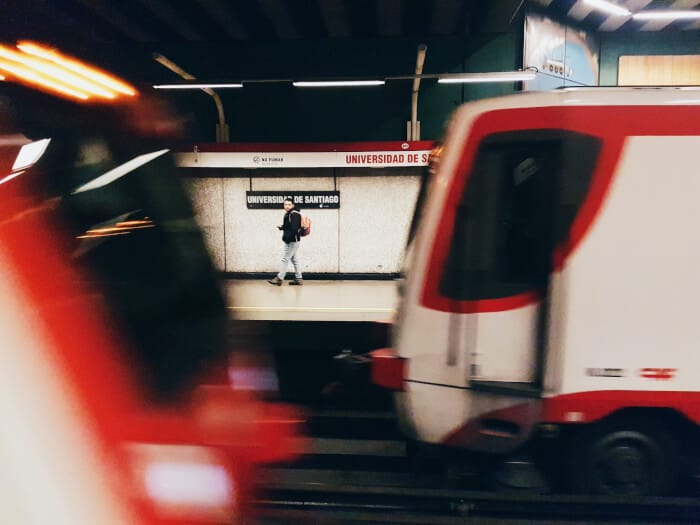 Red train with high speed and a man walking